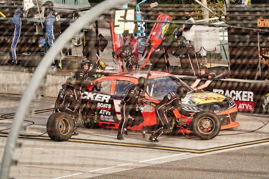 Dynamic shot capturing a NASCAR pit stop with crew in action at a Miami speedway.